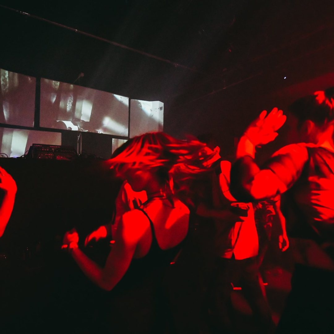Fotografía de un festival urbano con música, performances y ambiente único, capturando la emoción de salir de la zona de confort.